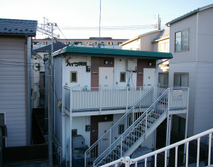 綱島街道から階段で降りる形の住宅地にある。後方に見えるのは東急線
