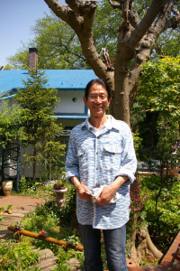 「日吉山荘」と鼠入俊之さん。日吉のマンション住まいの頃から「植木鉢がだんだんベランダに増えてきていました」と、この家を購入前からも花や草木に癒されていたと教えてくれました