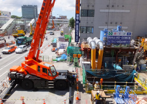 延期報道があった8月25日も炎天下のなかで建設工事はいつものように進められていた（新横浜駅前）