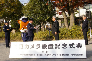 12月12日に新吉田第一公園（新吉田東6）にて行われた「防犯カメラ設置記念式典」で表彰される発起人の畠山英治（えいじ）さん（写真中央）、篠沢秀夫さん（同右）。表彰状を手にするのは陶山和美（すやまかずよし）港北警察署長