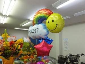 事務所内には訪問用の自転車も。岡野さんが関係した千葉県市川市の施設からのオープン祝いの花も届いていた