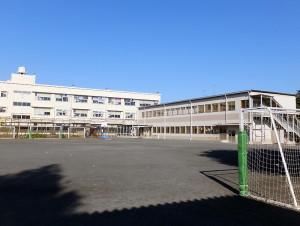 グラウンドに2階建てのプレハブ校舎が建てられている大曽根小学校