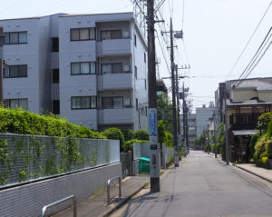 創業当時の「こじま寝装」は、日吉本町3丁目25（左側付近）にあったが、開業から2年もたたない1961（昭和36）年に、この付近で続々建てられたという銀行の寮建設に伴い、現在地に移転。当時の建物を引き車でひっぱってきたという。道路奥は日吉台中学校