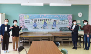 立体感と躍動感にあふれる「黒板アート」とともに、メインで作画した杉本さん、左右田美矢さん、中里校長、光城（みつしろ）めぐみPTA副会長（写真左より）