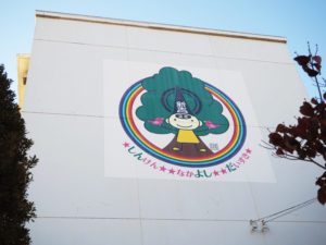 7月21日から約1カ月間をかけて新吉田小の校舎東側に描かれた「しんよしだくん」の巨大壁画。同校の「クスノキ」も描かれている
