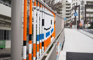 下田小学校脇のバス通りに新たに登場した「防護柵」に描かれたキャラクター「円ちゃん」など計18点のイラストを楽しみながら歩道を通行できる（工事最終日の3月23日）