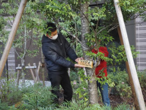 東邦レオの小山田さんが子どもたちにプラウドシティ内の樹木についてのレクチャーや日吉駅前のケヤキの木の搬送も実施。最後は樹木札の設置についてもアドバイスをおこなった（3月24日）