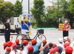 横浜Ｆ・マリノスのキャラクター「マリノスケ」と、公式チアリーティングチーム「トリコロールマーメイズ」のみうさん、かなこさんの2人が安全な自転車の乗り方を指導した（5月12日）