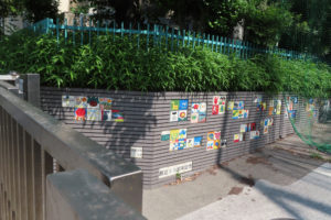 日吉元石川線（荏田綱島線）側に設置された創立30周年記念のタイルも色鮮やかに学校を彩る