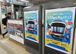 9月2日に「創立100周年」を迎える東急グループを祝うポスターが慶應義塾から寄贈された。隣には“100周年カウントダウン”で制作されたという駅ごとの社員・スタッフで撮影したという企画ポスターも（8月28日、日吉駅）