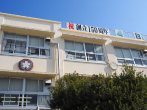 「祝・創立150周年」の横断幕と学校キャラクター「ぶんかちゃん」、校名の新しい屋上看板が披露された横浜市立日吉台小学校（3月7日）
