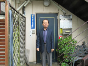 横浜市営地下鉄グリーンライン日吉本町駅にもほど近いオフィス前で取材に応じる青会長（2023年5月）