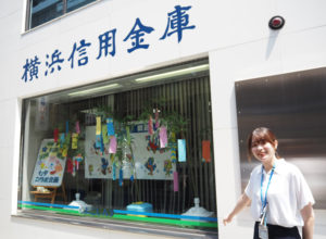 横浜信金綱島支店は外壁工事を終えたばかり。飾りつけを行った新入職員の小貫さん