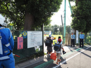 港北警察署の加藤署長や港北交通安全協会副会長の相沢さんも登校する児童を出迎えた（7月11日）