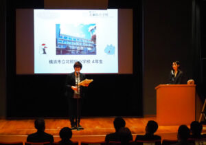 動画やスライドで活動の成果を紹介。北綱島小学校の発表では、佐藤安世教諭が横浜市の社会科のカリキュラムとして採用するための研究発表授業も行ったと報告していた
