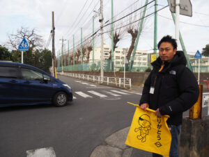 「ありがとう」と横浜市のマーク（き章）とともに書かれた横断旗はPTA会議室にあったものを使用している。「安心・安全な地域をつくっていくためにも、日々の見守り活動に協力を」と呼び掛ける