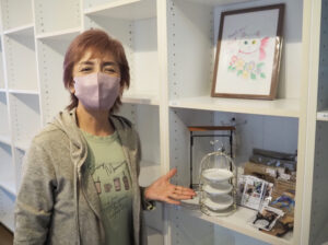 これまでの歩みを振り返るオーナーの小泉美菜さん。会員からプレゼントされたという「イラスト額」も店内に掲示。ワイヤークラフト作家としての活動は継続していく予定だという