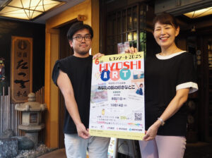 第1回開催時から企画の中心を担う日吉普通部通り会の島名貴子さん（右）、水口辰之さん。島名さんが経営する「遊ZENたつ吉」本店前で。個人情報の収集についても最低限のみ記載し募集する方法に刷新。募集店舗も1店舗に絞ることで個人情報の保護を試みる