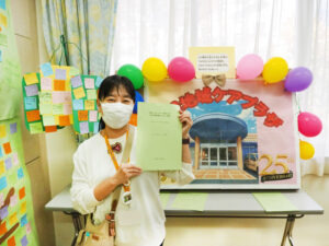 下田小学校の全校児童に呼び掛けて送られた「下田メッセージツリー」（左）と、メッセージを抜粋しまとめた小冊子を手にする冨田さん（11月16日、下田地域ケアプラザ）