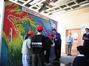 京浜河川事務所新横浜出張所長の影山茂さんから「バクちゃん」のぬいぐるみと記念バッジが手渡された