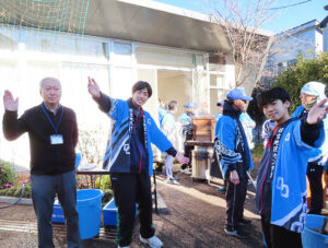 別館前で餅つき体験を手伝った関口君（左から2人目）、梶村春文君