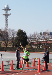 第41回「港北駅伝大会」で初優勝のゴールテープを切る吉地区連合町内会チーム（日吉連合Aチーム）の井上汐莉さん（1月18日）