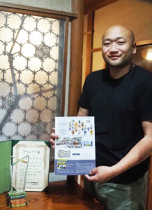 日本アルバム写真家協会（事務所：滋賀県草津市）の「卒業アルバム」小学校部門でグランプリ賞を受賞したことを喜ぶ冨川さん。地元・大曽根小学校（大曽根2）の2023年度（2024年）制作の作品がエントリーの対象となった