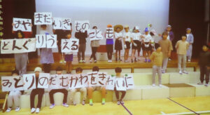 町田市立小山田小学校は鶴見川の源流に最も近い学校。「鶴見川源流保水の森」でのクヌギの植樹活動やバスで鶴見川の河口を訪問するなどの流域学習に取り組んでいることも報告。 今回は学習成果を児童が劇で演じた様子を動画で発表。源流での活動を知ってもらいたいとの想いを込めている