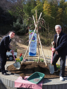 長瀬会長と竹下区長、そして地域の子どもたちが、新たなシンボルツリー枝垂れ梅(クレハシダレ)の花壇で記念の植樹セレモニーに臨みました