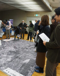 1966(昭和41)年の5メートル四方の航空写真マットが敷かれており、入口で配布された異なる年代の写真と見比べる試みも行われていました