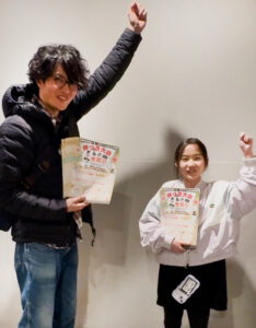 プラウドシティ日吉(箕輪町2)でのポスティングにも挑戦。代表の宇野さん(左)は「餅つきも昔遊びもよくあるイベントかもしれませんが、子どもたちにスポットを当てることで、一味違うイベントになると思っています。一生懸命、楽しそうに頑張る子供たちを起点とし、多くの笑顔を生み出すイベントになるよう、今準備のラストスパートを頑張っています。当日みなさんにお会いできることを楽しみにしています」と語る